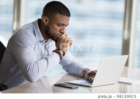 African businessman learns new software, working on project use laptop African businessman learns new software, working on project use laptop 98139923