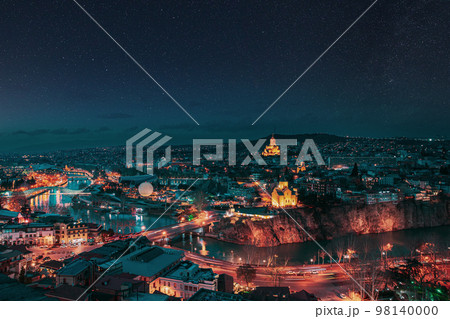 Tbilisi, Georgia. night dusk evening Top View Of Famous Landmarks In spring Evening dusk night. starry sky night sky above Georgian Capital Skyline Cityscape. altered stars sky Tbilisi, Georgia. night dusk evening Top View Of Famous Landmarks In spring Evening dusk night. starry sky night sky above Georgian Capital Skyline Cityscape. altered stars sky 98140000