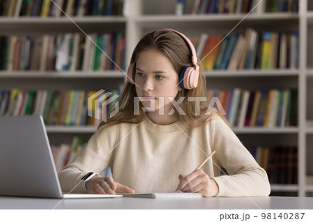 Serious hardworking smart student girl in wireless headphones 98140287