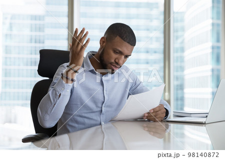 Frustrated African man read bad news in postal letter 98140872