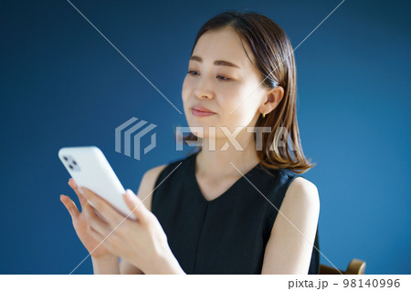 スマートフォンを手にする女性 スマートフォンを手にする女性 98140996