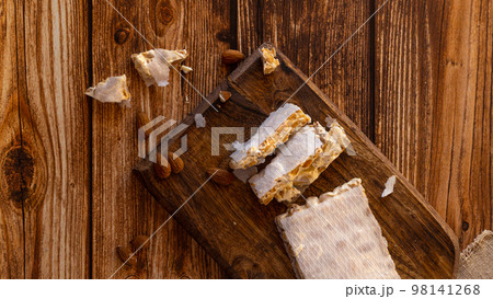 Top view of Almond turron dessert slices on wooden desk Top view of Almond turron dessert slices on wooden desk 98141268
