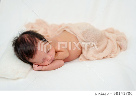 newborn baby sleeping in blanket on bed newborn baby sleeping in blanket on bed 98141706