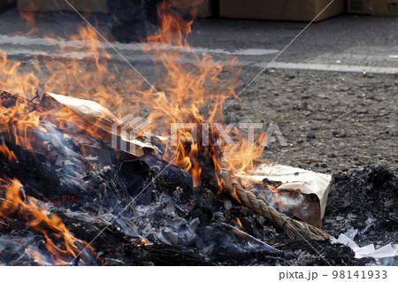正月飾りやだるま等の縁起物を焼いて燃やした煙とともに神様を見送る小正月の行事のどんど焼き 98141933