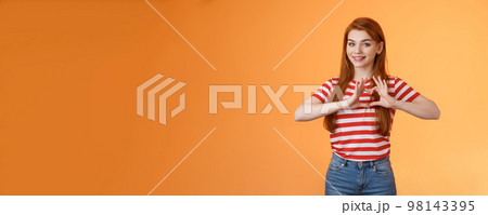 Cute lovely cheerful redhead girlfriend express love and cherish relationship, celebrating anniversary show heart sign, smiling tenderly, confess sympathy, stand orange background Cute lovely cheerful redhead girlfriend express love and cherish relationship, celebrating anniversary show heart sign, smiling tenderly, confess sympathy, stand orange background 98143395