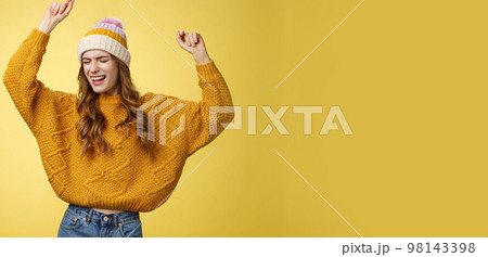 Oh yeah party vibe. Portrait joyful carefree dancing happy girl wearing winter hat sweater having fun raising hands up dancing moving music rhythm celebrating success positive news Oh yeah party vibe. Portrait joyful carefree dancing happy girl wearing winter hat sweater having fun raising hands up dancing moving music rhythm celebrating success positive news 98143398