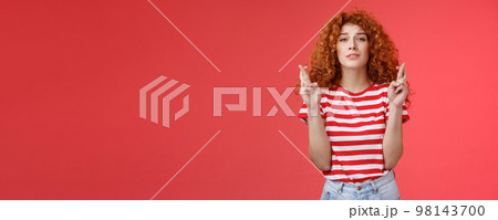Nervous young silly timid cute redhead ginger girl anticipating hopeful results believe praying squinting intense worry to win cross fingers good luck wish come true red background Nervous young silly timid cute redhead ginger girl anticipating hopeful results believe praying squinting intense worry to win cross fingers good luck wish come true red background 98143700