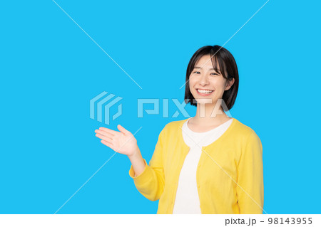 笑顔で案内する女性 98143955