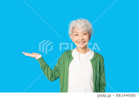 笑顔で案内するシニア女性 98144000