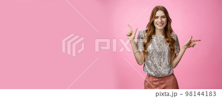 Pretty confident carefree caucasian woman enjoying party pointing sideways different sides smiling unbothered happy show you choices, opportunities, make decision standing pink background 98144183