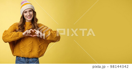 Girl brings peace love show heart gesture tilting head friendly smiling expressing sympathy passion confessing boyfriend warm feelings, heartbit sign, grinning flirty, standing yellow background Girl brings peace love show heart gesture tilting head friendly smiling expressing sympathy passion confessing boyfriend warm feelings, heartbit sign, grinning flirty, standing yellow background 98144342