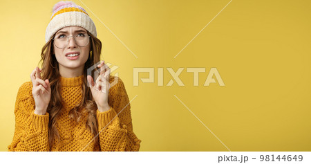 Worried cute girl nerd hope pass exam standing nervous cross fingers good luck frowning grimacing look up praying supplicating anticipating results anxiously, wearing glasses, yellow background Worried cute girl nerd hope pass exam standing nervous cross fingers good luck frowning grimacing look up praying supplicating anticipating results anxiously, wearing glasses, yellow background 98144649