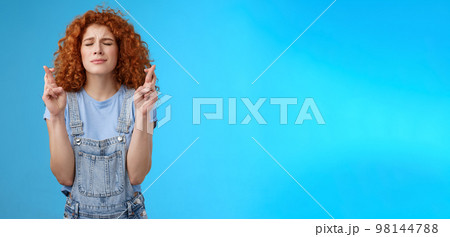 Intense nervous attractive redhead curly-haired hopeful focused girl praying supplicating asking god make dream come true cross fingers good luck anticipating important news wanna wish fulfill 98144788