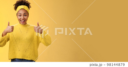 Supportive friendly modern trendy african-american female friend supporting you show thumbs-up keep up good work gesture proud doing best effort, liking result approving plan, yellow background 98144879