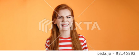 Close-up sassy good-looking cheerful redhead sly girl smiling toothy white perfect grin, satisfied dental clinic professional cleaning, standing orange background happy, joyful summer mood Close-up sassy good-looking cheerful redhead sly girl smiling toothy white perfect grin, satisfied dental clinic professional cleaning, standing orange background happy, joyful summer mood 98145892