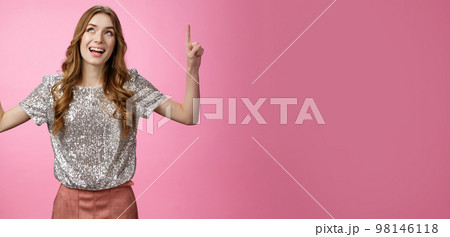 Charming excited good-looking glamour young girl look up thrilled joyful pointing index finger top upwards smiling amazed enjoyment perfect weather, standing happily pink background 98146118