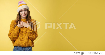 Thankful touched young woman receive warm pleasant compliment press palms chest thanking appreciating nice moving gesture smiling delighted happy grateful standing yellow background 98146175