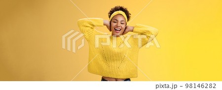 Carefree outgoing young charming african-american girl lay back hands behind head relaxing stretching feel lazy enjoying free day-off smiling broadly spend leisure having fun yellow background Carefree outgoing young charming african-american girl lay back hands behind head relaxing stretching feel lazy enjoying free day-off smiling broadly spend leisure having fun yellow background 98146282