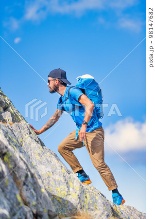 A man during a mountain climb in the wild 98147682