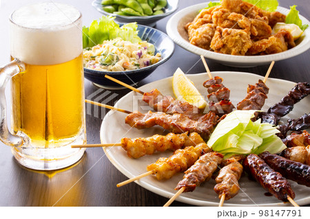 居酒屋の焼鳥の盛合せとビール 98147791