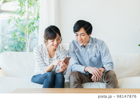 スマホを見る若いカップル スマホを見る若いカップル 98147876