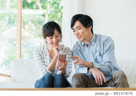 スマホを見る若いカップル スマホを見る若いカップル 98147879