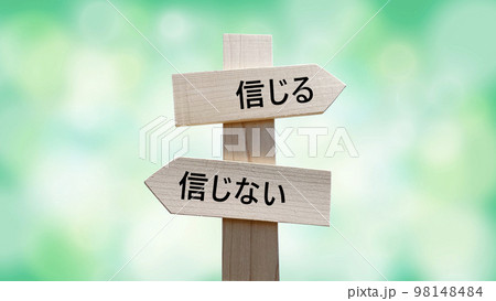 信じると信じない文字入り道しるべと緑背景 信じると信じない文字入り道しるべと緑背景 98148484
