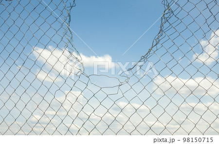 Broken metal mesh fence 98150715