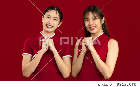 Young LGBTQ asian couple in red chinese dress posing on wishing, pray and greeting on red background. Happy Chinese New Year. 98152089