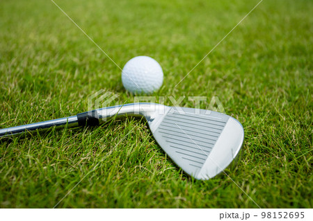 Golf clubs and ball on a green grass, background Golf clubs and ball on a green grass, background 98152695