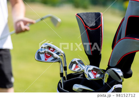 Black golf club bag on the golf course against a background of green grass. High quality photo Black golf club bag on the golf course against a background of green grass. High quality photo 98152712
