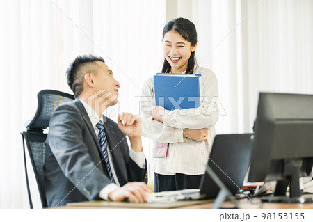 オフィスで上司と話すキャリアウーマン 98153155