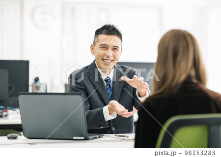 窓口で相談を受けるビジネスマン 98153283