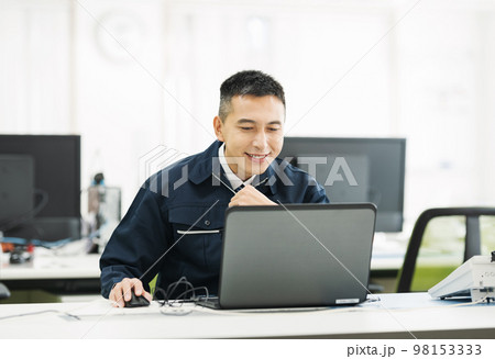 パソコンで事務作業をする作業服の男性 98153333