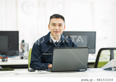パソコンで事務作業をする作業服の男性のポートレート 98153334