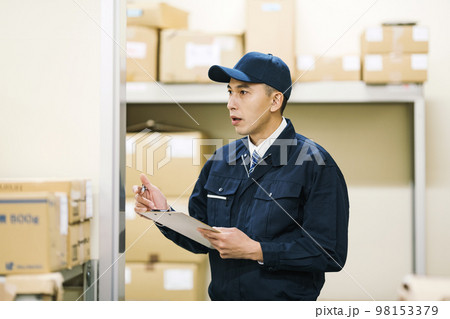 物流倉庫で検品をする作業服の男性 98153379