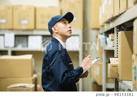 物流倉庫で検品をする作業服の男性 物流倉庫で検品をする作業服の男性 98153381