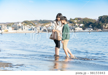 冬の海辺で遊ぶ男の子と女の子 98155943