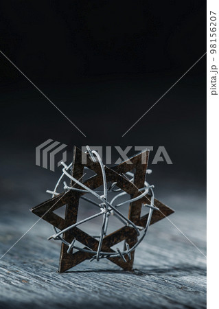old star of david tied with some barbed wire 98156207