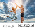 Sport man and woman exercise on beach at sunset 98158216