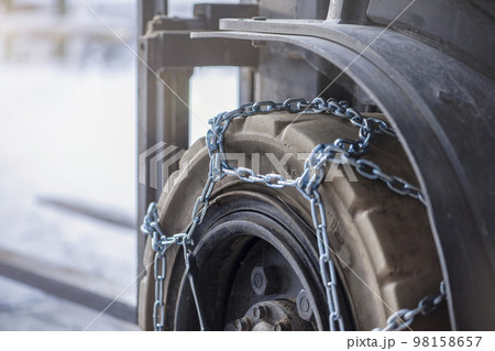 Cargo loader in winter on snow. The loader ride on snow with chains on the wheels to reduce slippage and spin. Driving safety in winter conditions 98158657