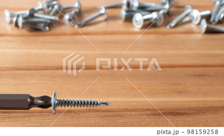 A screwdriver and self-cutters on a brown wooden background. Building tools to repair the house. A screwdriver and self-cutters on a brown wooden background. Building tools to repair the house. 98159258