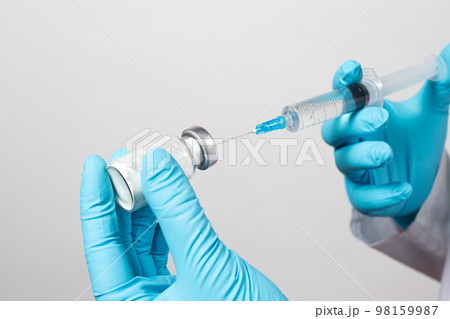 The gloved hands of a nurse dilute the antibiotic with saline. Close-up photo. Step-by-step instruction, step one 98159987