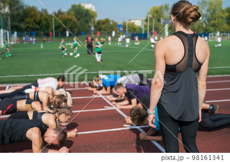 Female coach and group of children conducts a training session 98161341
