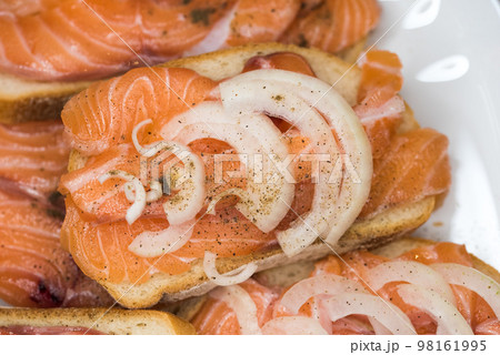 Bread with fresh salted salmon fillet isolated on white background, top view 98161995