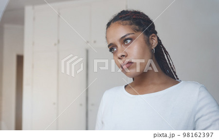 Sad, thoughtful and depressed woman in her home feeling alone and isolated. Mock up for depression, sadness and mental health issues. Thinking, worried and upset young girl with problems in her room 98162397