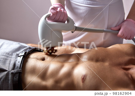 Man receiving fat reductive skin lifting body treatment in cosmetology clinic Man receiving fat reductive skin lifting body treatment in cosmetology clinic 98162904