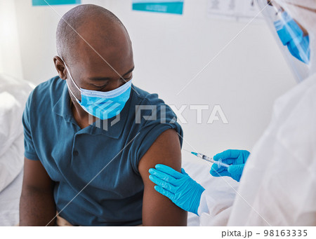 Vaccine, injection and virus cure for covid, disease and pandemic illness from doctor, healthcare or medical professional. Male patient with mask being injected in arm by hazmat suit frontline worker Vaccine, injection and virus cure for covid, disease and pandemic illness from doctor, healthcare or medical professional. Male patient with mask being injected in arm by hazmat suit frontline worker 98163335