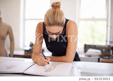 Designing the latest trends. an attractive young woman working on a clothing design. Designing the latest trends. an attractive young woman working on a clothing design. 98163603