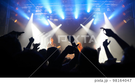 Concert, dance and audience at a band performance, techno festival and event with people on a stage in the dark. Night club, dancing and crowd with freedom, energy and rock at a music festival 98164047